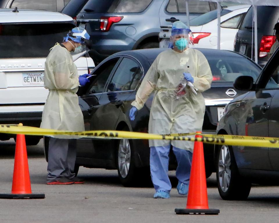 En Arkansas, personal médico de Baptist Health-Fort Smith realiza pruebas del COVID-19 el 2 de julio en un nuevo sitio en Arkansas. El sitio de pruebas desde el automóvil estaba abierto de 7:00 a 11:00 a.m., siete días a la semana.