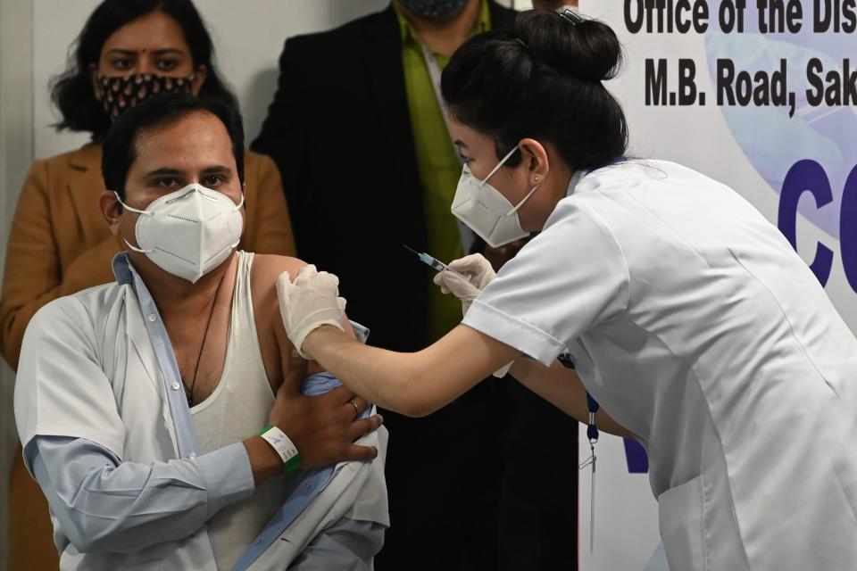 A medical worker inoculates a colleague with a Covid-19 coronavirus vaccine at the All India Institute of Medical Science (AIIMS) in New Delhi in January 16, 2021. (Photo by Sajjad HUSSAIN / AFP) (Photo by SAJJAD HUSSAIN/AFP via Getty Images)