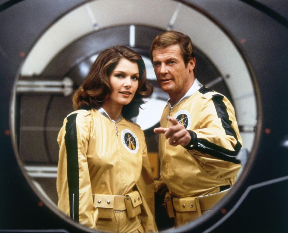 <p>Roger Moore and actress Lois Chiles on the set of <em>Moonraker.</em></p>