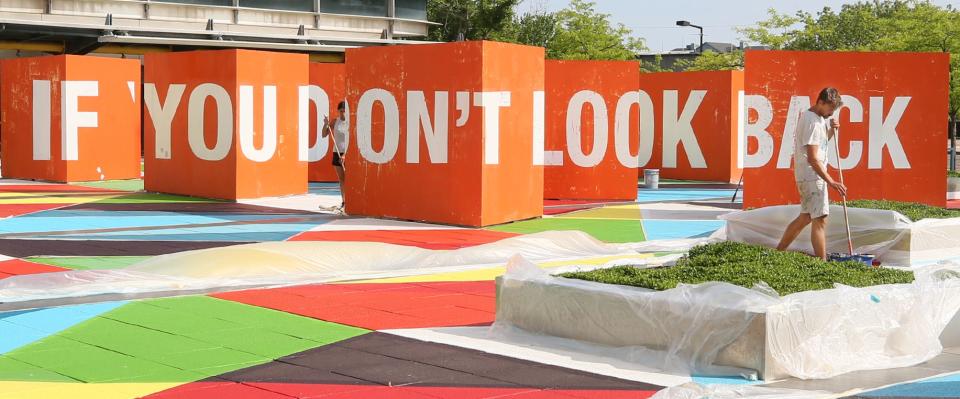 Boa Mistura artist Juan Jaume refreshes the paint at the STEM Plaza in Akron. The orange blocks with the letters will be painted later this week.