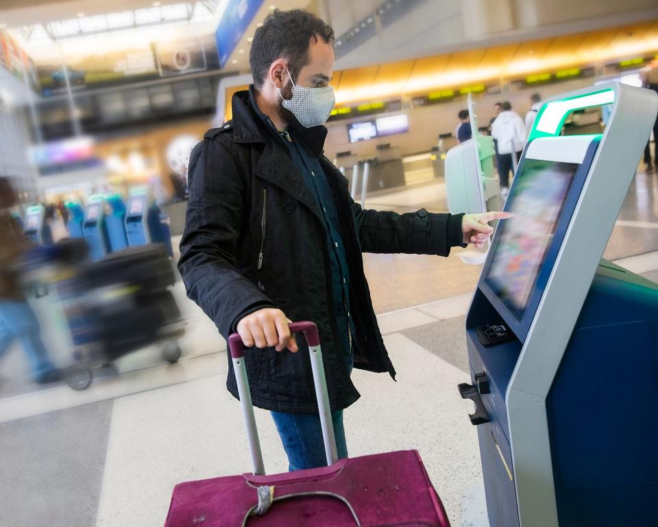 An airport traveler wears a face mask.