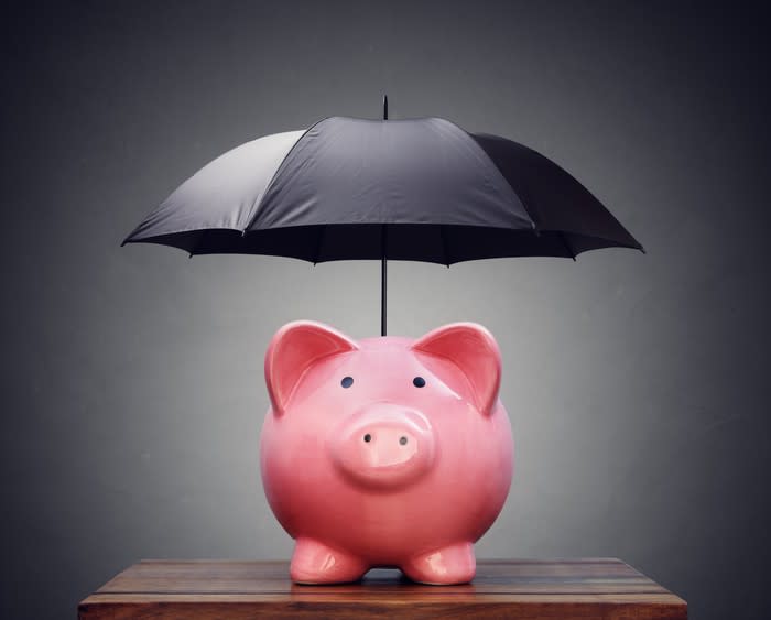 A piggy bank with an umbrella opened above it