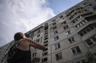 FILE - A man pulls down furniture from his apartment house on a rope in Saltivka district, after Russian attacks in Kharkiv, Ukraine, on Tuesday, July 5, 2022. As Russia's invasion of Ukraine grinds into its fifth month, some residents close to the front lines remain in shattered and nearly abandoned neighborhoods. One such place is Kharkiv's neighborhood of Saltivka, once home to about half a million people. Only perhaps dozens live there now, in apartment blocks with no running water and little electricity. (AP Photo/Evgeniy Maloletka, File)