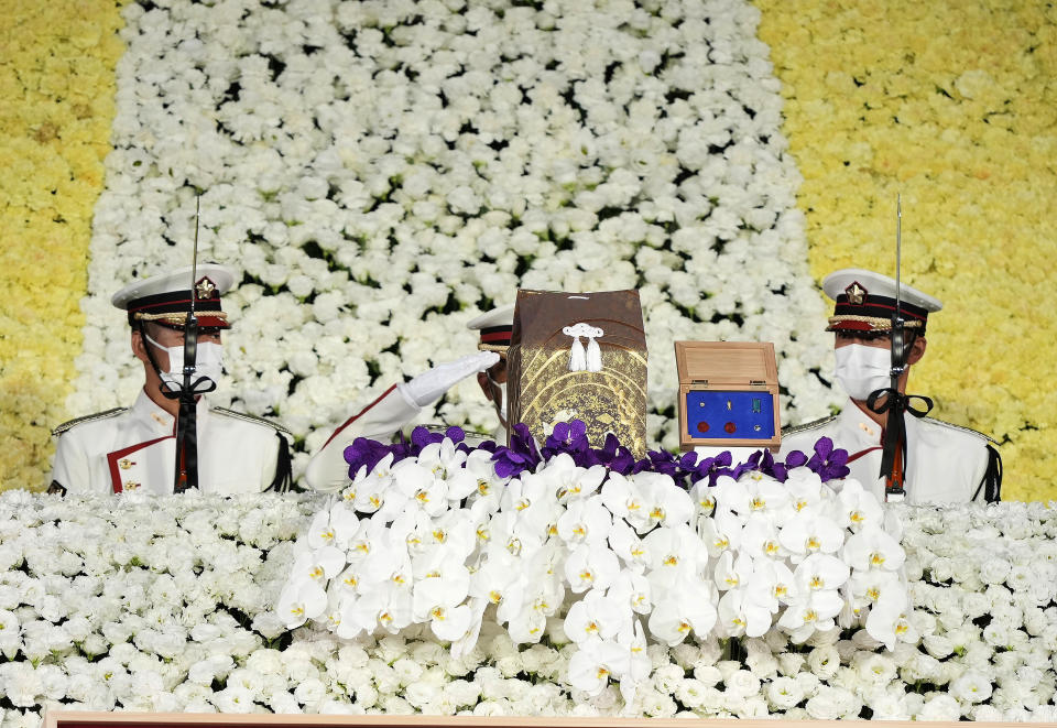 Honor guards salute a cinerary urn containing former Prime Minister Shinzo Abe's ashes on the altar during his state funeral, Tuesday, Sept. 27, 2022, in Tokyo. Abe was assassinated in July. (Franck Robichon/Pool photo via AP)