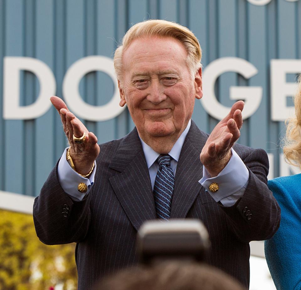 FILE - Los Angeles Dodgers broadcaster Vin Scully thanks fans at the unveiling of a street sign bearing his name at the entrance to Dodger Stadium, in Los Angeles on April 11, 2016. Scully, whose dulcet tones provided the soundtrack of summer while entertaining and informing Dodgers fans in Brooklyn and Los Angeles for 67 years, died Tuesday night, Aug. 2, 2022, the team said. He was 94. (AP Photo/Damian Dovarganes, File)