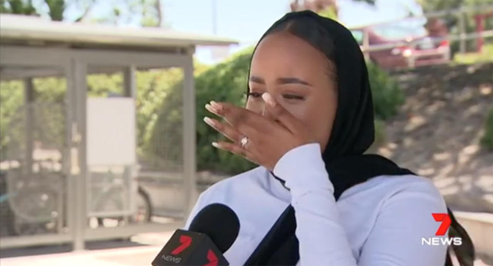 Fahima Adan cried recalling the alleged racist attack, saying her headscarf was ripped off by a woman during a commute. Source: 7 News
