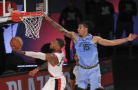 Portland Trail Blazers Damian Lillard (0) shoots the ball against Memphis Grizzlies Brandon Clarke (15) during the second half of an NBA basketball game Friday, July 31, 2020, in Lake Buena Vista, Fla. (Mike Ehrmann/Pool Photo via AP)