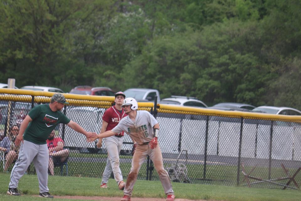 Oak Harbor coach Nick Lance congratulates Brayden Butzin after his triple.