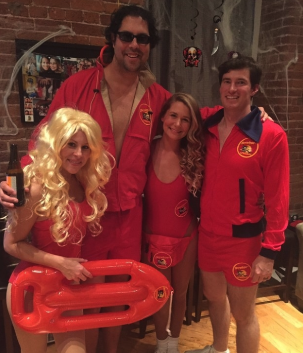 A group of friends dressed in red lifeguarding uniforms