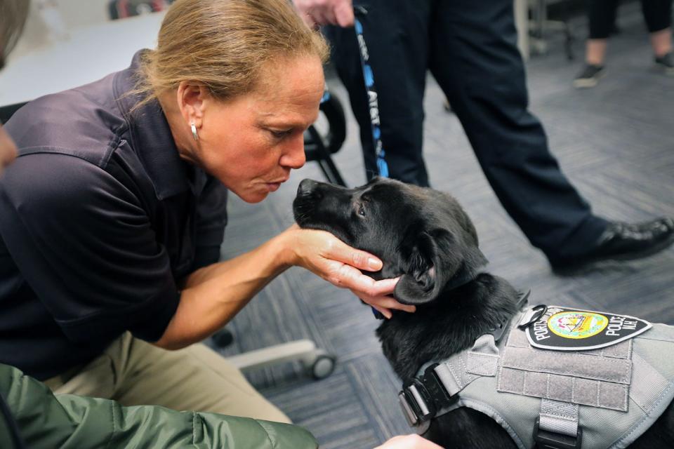 Portsmouth police Detective Rochelle Jones greets Mason, the department's comfort dog in training, at the station Wednesday, March 8, 2023.