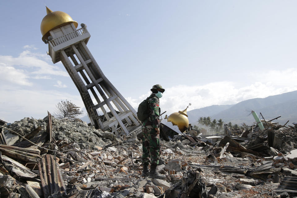 FILE - In this Oct. 6, 2018 file photo, a soldier stands near a toppled mosque as recovery efforts continue at the earthquake-hit Balaroa neighborhood in Palu, Central Sulawesi, Indonesia. (AP Photo/Aaron Favila)