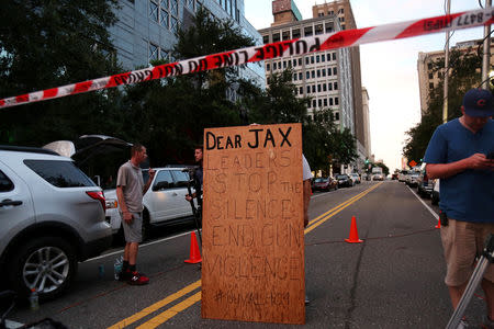 A man holds a sign in support of gun control outside of The Jacksonville Landing after a shooting in Jacksonville, Florida August 26, 2018. REUTERS/Joey Roulette