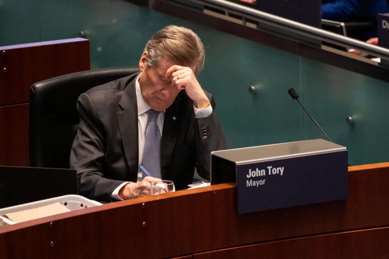 Toronto Mayor John Tory writing at his chambers desk at a Toronto council meeting on Feb 15, 2023 (Michael Wilson/CBC - image credit)