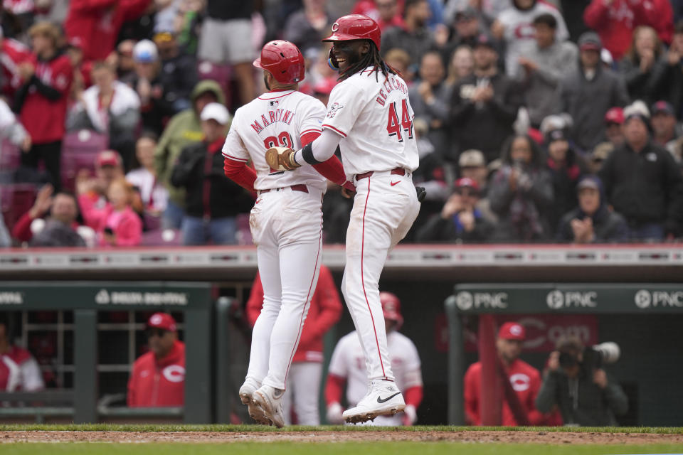 Cincinnati Reds' Elly De La Cruz, right, and Reds designated hitter Nick Martini, left, celebrate after they scored off Christian Encarnacion-Strand's double in the sixth inning of a baseball game against the Los Angeles Angels, Sunday, April 21, 2024, in Cincinnati. (AP Photo/Carolyn Kaster)