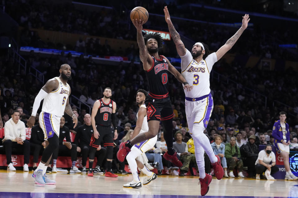 Chicago Bulls guard Coby White (0) shoots past Los Angeles Lakers forward Anthony Davis (3) during the first half of an NBA basketball game Sunday, March 26, 2023, in Los Angeles. (AP Photo/Marcio Jose Sanchez)