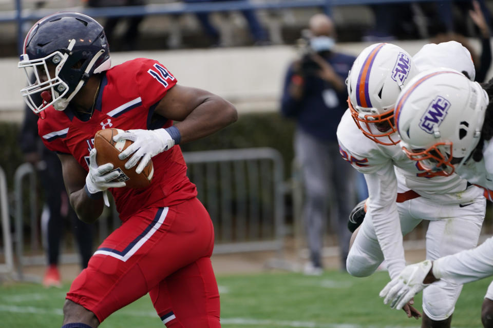 Jackson State wide receiver Christian Allen (14) sprints away from Edward Waters defenders during the second half of an NCAA college football game in Jackson, Miss., Sunday, Feb. 21, 2021. The game marked the coaching debut of Sanders. (AP Photo/Rogelio V. Solis)