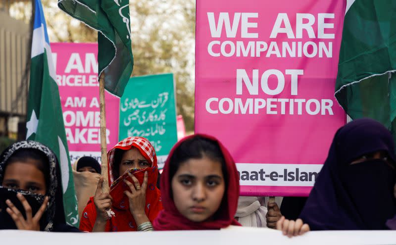 Women supporters of the religious and political party Jamaat-e-Islami (JI) hold signs as they take part in an Aurat March, or Women's March, in Karachi