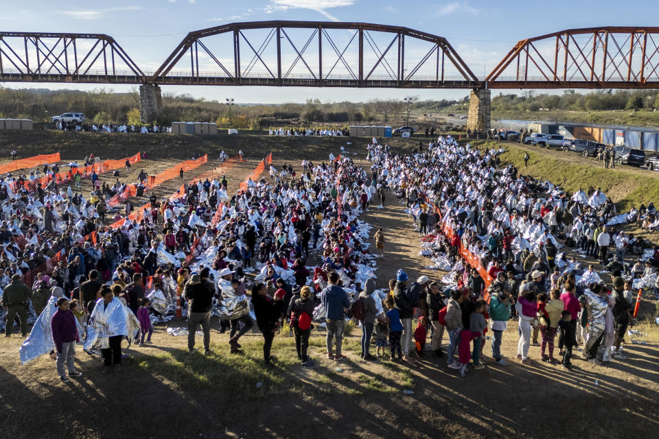 In an aerial view, thousands of immigrants, most wearing thermal blankets, await processing at a U.S. Border Patrol transit center on December 19, 2023 in Eagle Pass, Texas. / Credit: John Moore / Getty Images