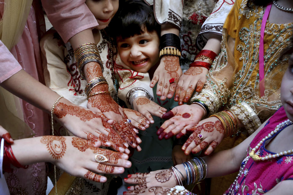 Muslim girls display their hands painted with traditional henna to celebrate Eid al-Fitr holidays, marking on the end of the fasting month of Ramadan, in Peshawar, Pakistan, Thursday, May 13, 2021. (AP Photo/Muhammad Sajjad)