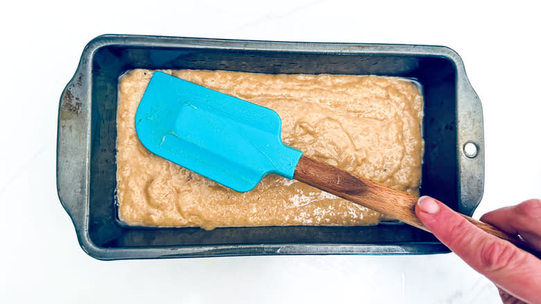 spatula smoothing batter in pan