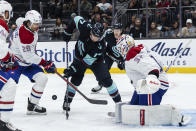 Montreal Canadiens defenseman Johnathan Kovacevic, left, and goalie Jake Allen, right, and Seattle Kraken forward Jaden Schwartz work for the puck in front of the net during the second period of an NHL hockey game Tuesday, Dec. 6, 2022, in Seattle. (AP Photo/Stephen Brashear)