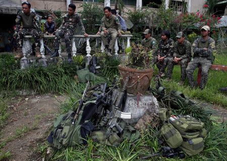 Soldiers take a break inside a compound after government troops cleared the area from pro-Islamic State militant groups inside a war-torn area in Bangolo town, Marawi City, southern Philippines October 23, 2017. REUTERS/Romeo Ranoco