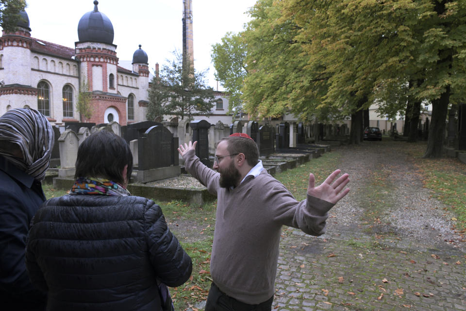 Jeremy Borovitz gestures as he stays in front of a synagogue in Halle, Germany, Thursday, Oct. 10, 2019. A heavily armed assailant ranting about Jews tried to force his way into a synagogue in Germany on Yom Kippur, Judaism's holiest day, then shot two people to death nearby in an attack Wednesday that was livestreamed on a popular gaming site. (AP Photo/Jens Meyer)