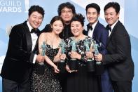 <em>Parasite</em> cast Song Kang-ho, Cho Yeo-jeong, director Bong Joon-ho, Lee Jung-eun, Choi Woo-shik, and Lee Sun-kyun pose in the press room with the trophy for outstanding performance by a cast in a motion picture during SAG Awards in L.A. on Sunday. 