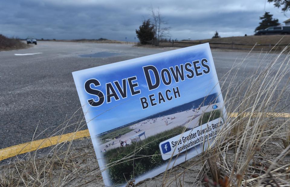 In this March 2023 photo, a "Save Dowses Beach" sign flutters in a strong north wind at the entrance to Dowses Beach in Osterville which would be the landfall location for the offshore wind farm Commonwealth Wind. A group opposed to using the beach for the cable landfall has posted signs around the village. A new poll conducted for an offshore wind developer says there is bipartisan support among Massachusetts voters for building offshore wind projects.