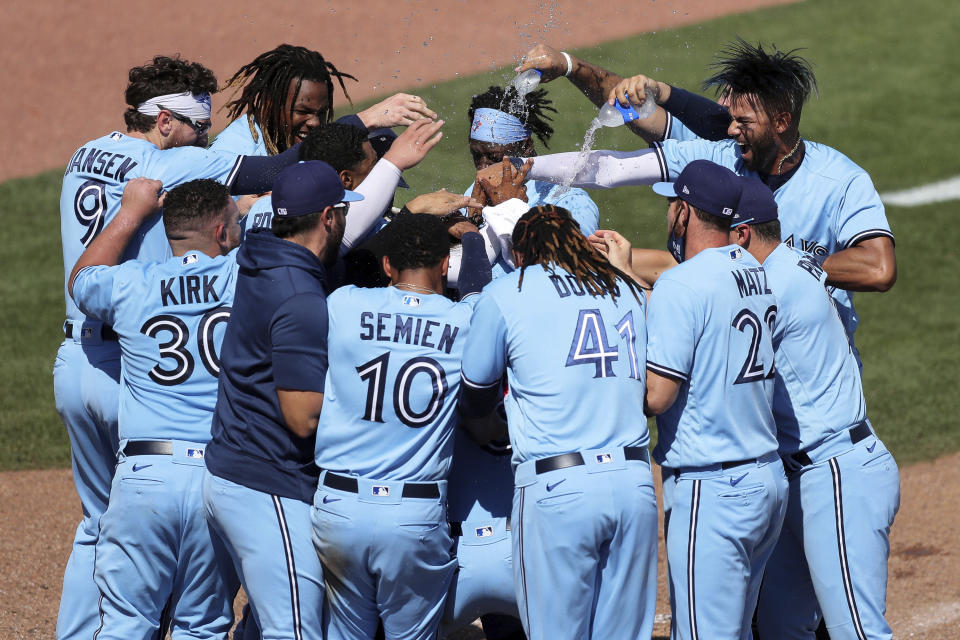 Los jugadores de los Azulejos de Toronto celebran tras la victoria 5-4 ante los Yanquis de Nueva York, el miércoles 14 de abril de 2021, en Dunedin, Florida. (AP Foto/Mike Carlson)