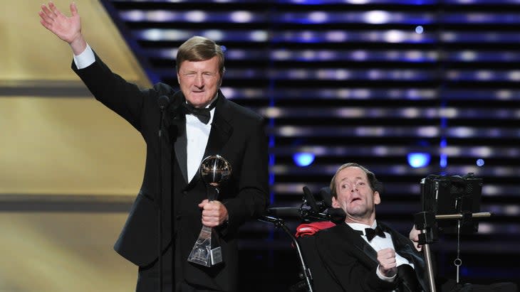 Father and son duo dressed up on stage and receiving an award