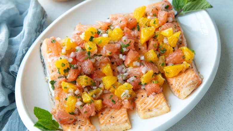 baked salmon with citrus salsa on white platter