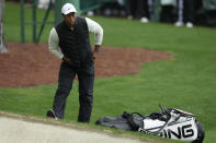 Tiger Woods stretches by the green on the 16th hole during the weather delayed second round of the Masters golf tournament at Augusta National Golf Club on Saturday, April 8, 2023, in Augusta, Ga. (AP Photo/Mark Baker)