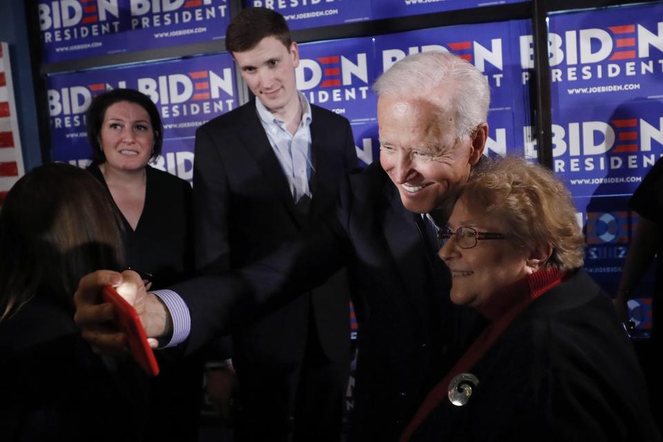 Former vice president and Democratic presidential candidate Joe Biden takes a selfie with a reporter during a campaign stop at the Community Oven in Hampton, N.H., Monday, May 13, 2019. (AP Photo/Michael Dwyer)