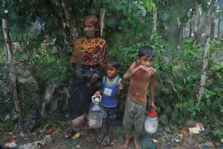 Rohingya refugees stand by the road in the rain outside their camp near Cox's Bazar, Bangladesh, October 3, 2017. REUTERS/Damir Sagolj