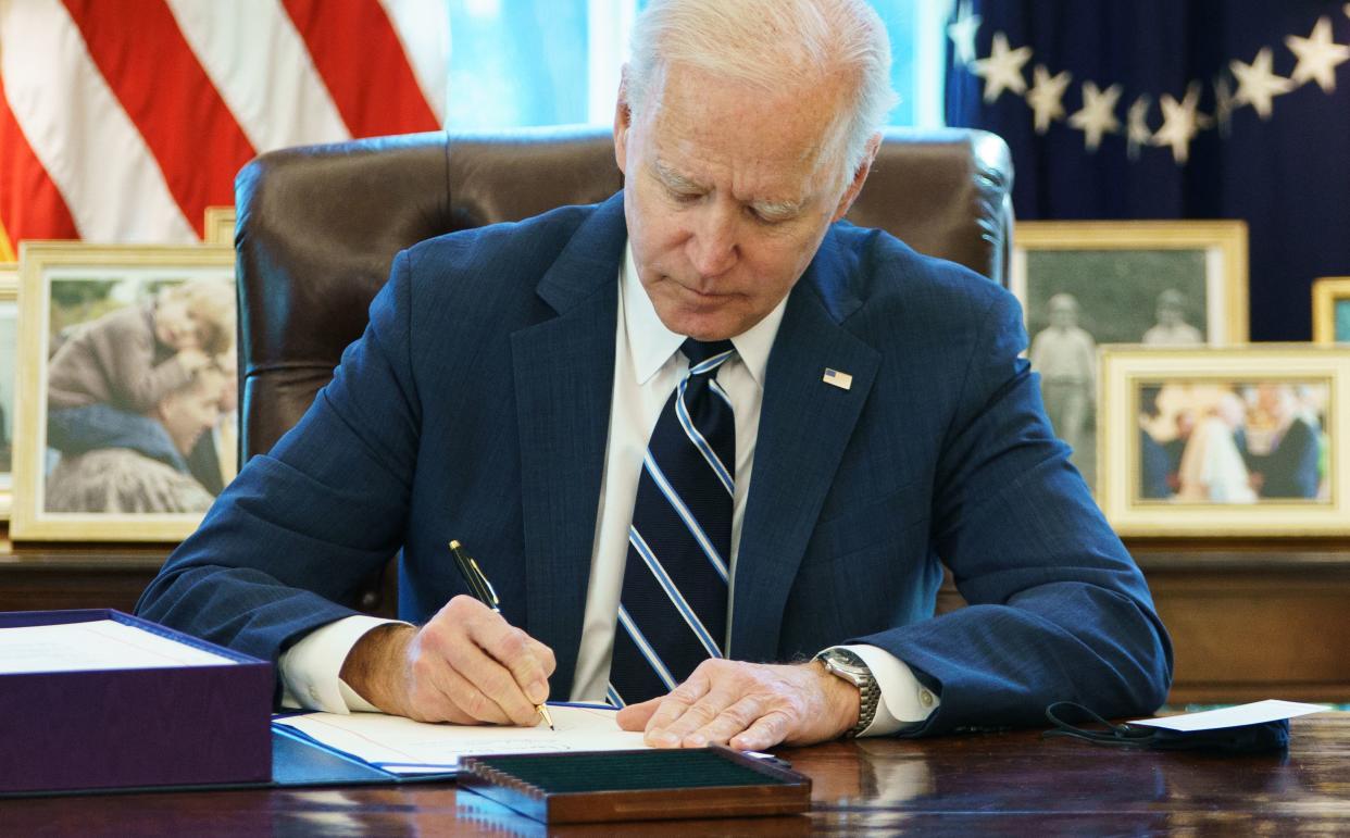 US President Joe Biden signs the American Rescue Plan on March 11, 2021, in the Oval Office of the White House in Washington, DC. - Biden signed the $1.9 trillion economic stimulus bill and will give a national address urging 