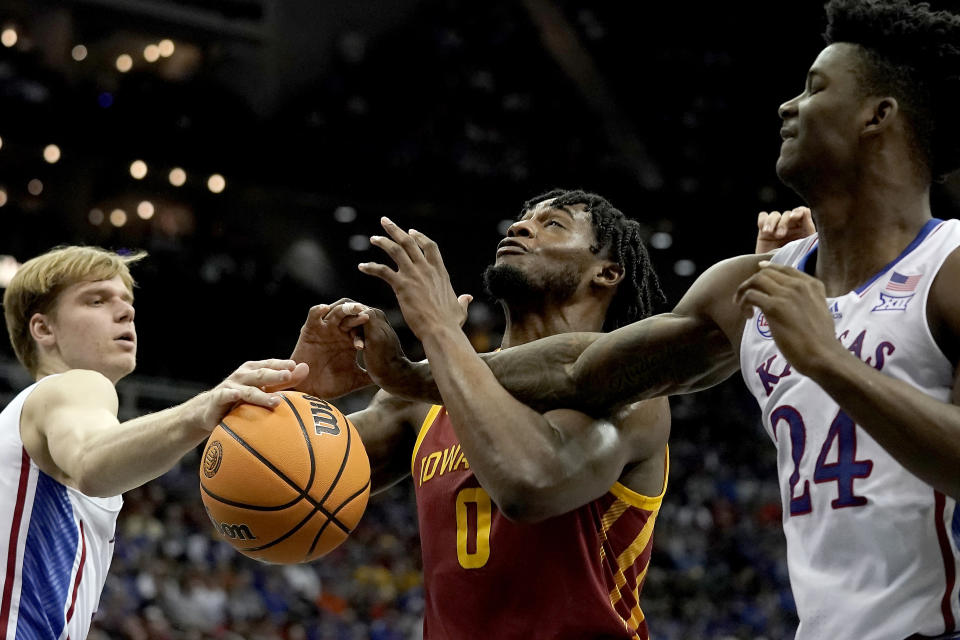 Kansas guard Gradey Dick, left, and forward K.J. Adams Jr. (24) knock the ball away from Iowa State forward Tre King (0) during the first half of an NCAA college basketball game in the semifinal round of the Big 12 Conference tournament Friday, March 10, 2023, in Kansas City, Mo. (AP Photo/Charlie Riedel)