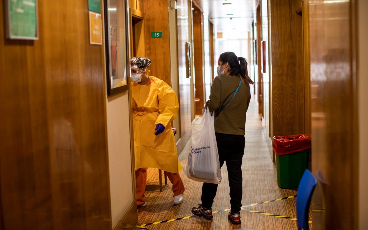 A coronavirus patient is shown to her room in a quarantine hotel in Madrid - Bernat Armangue/AP