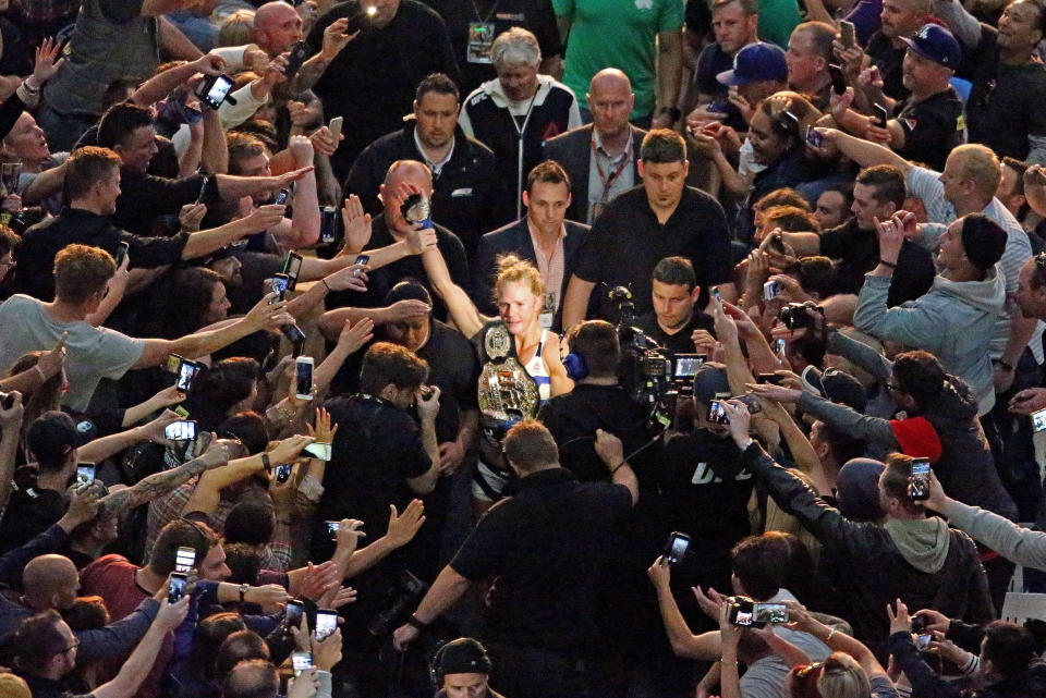 MELBOURNE, AUSTRALIA - NOVEMBER 15:  New UFC women's bantamweight champion Holly Holm (C) of the United States celebrates as she makes her way through the crowd as she leaves the arena after her victory over Ronda Rousey of the United States in their UFC women's bantamweight championship bout during the UFC 193 event at Etihad Stadium on November 15, 2015 in Melbourne, Australia.  (Photo by Scott Barbour /Zuffa LLC/Zuffa LLC via Getty Images)