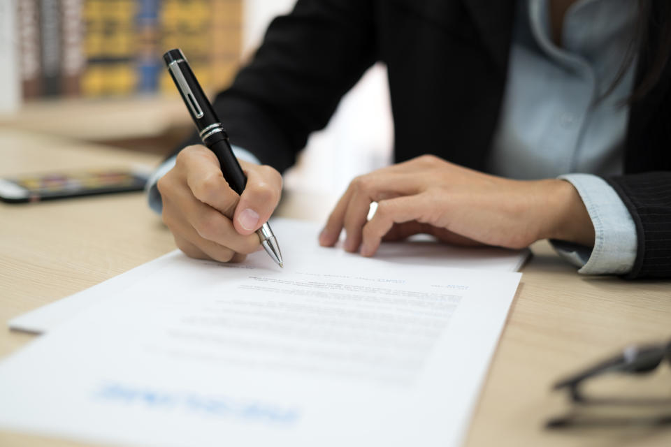 Close up of woman signing contract in job application form