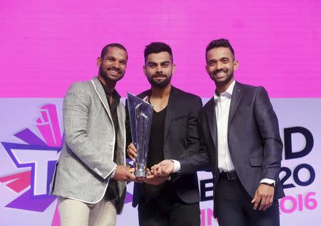 (L-R) Indian cricket players Shikhar Dhawan, Virat Kohli and Ajinkya Rahane, pose with a World Twenty20 trophy during a ceremony to announce the fixtures in Mumbai, India, December 11, 2015. REUTERS/Shailesh Andrade