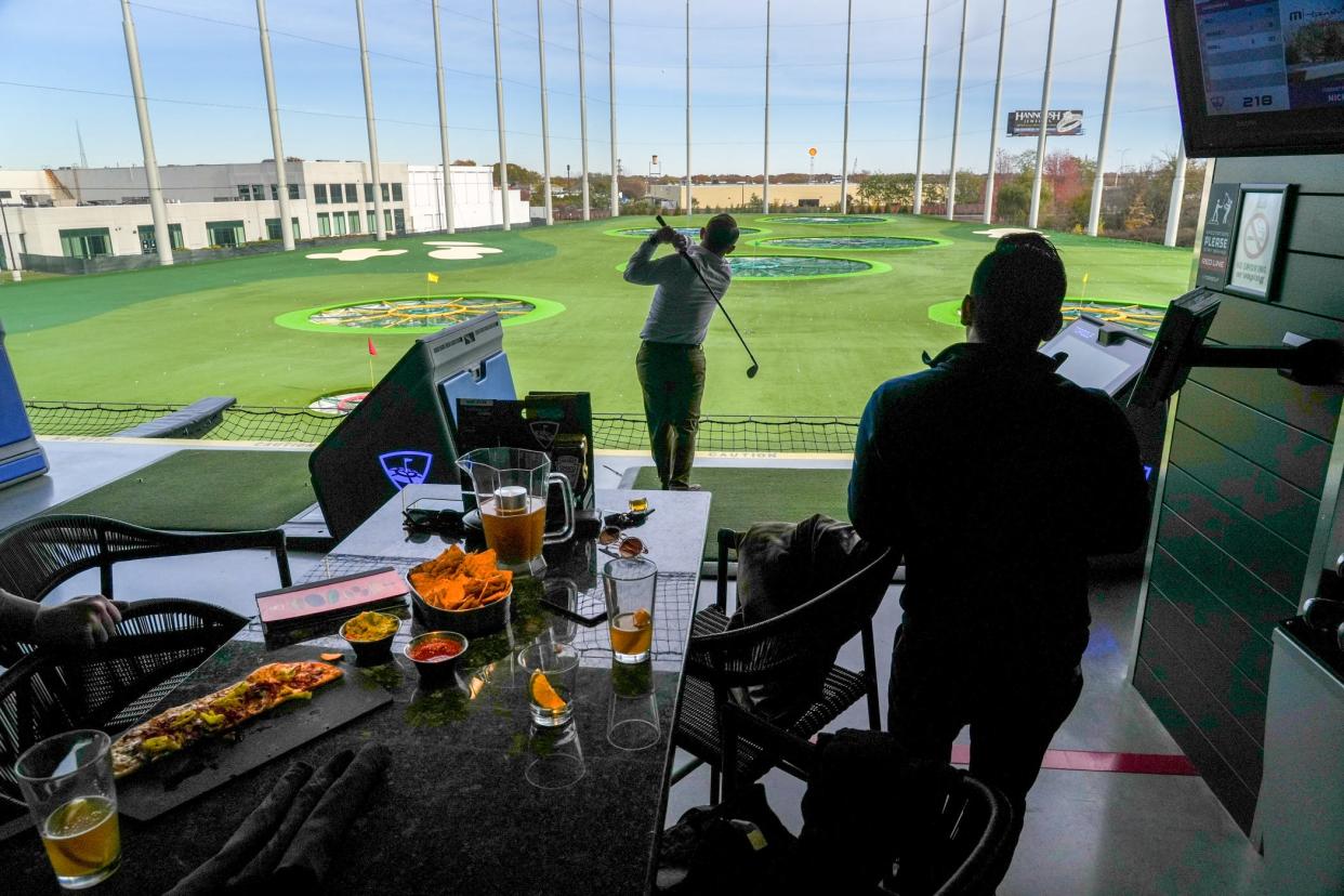 Topgolf combines a bar and grill atmosphere with a fully functional driving range on multiple tiers, where players can hit golf balls leisurely or set up games for their group.