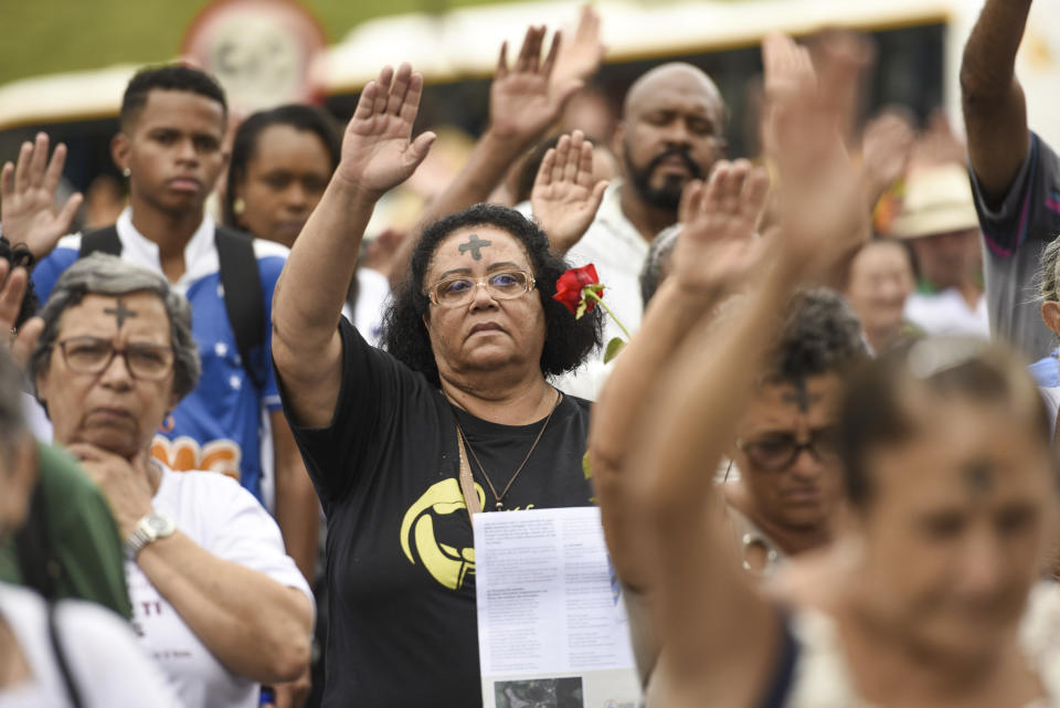 People pay tribute to those who died in the dam disaster last year in Brumadinho city, Minas Gerais state, Brazil, Saturday, Jan.25, 2020. The wave of mud and debris that on Jan. 25, 2019 buried the equivalent of 300 soccer pitches and killed 270 people, continues to barrel over residents' minds, the local economy and the environment, one year later. (AP Photo/Gustavo Andrade)