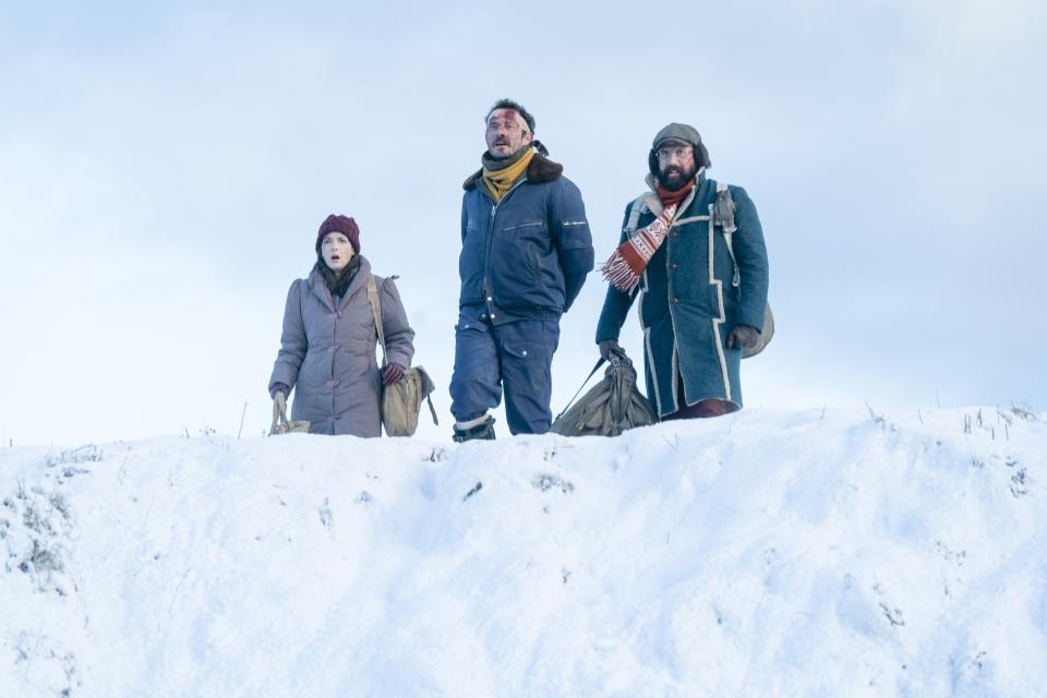 three of the characters walking in snow with large bags