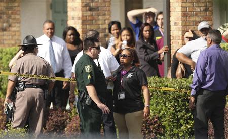 Parents wait behind as police consult after several children were injured after being struck by a vehicle at a KinderCare Learning Center in Winter Park, Florida April 9, 2014. REUTERS/Stephen M. Dowell/Orlando Sentinel