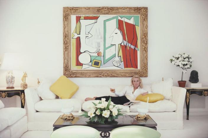 <p>Forget the floral sofas of the '70s. Contemporary couches in the 1980s were low-slung and deep-set—ideal for reclining, as socialite Mollie Wilmot models here.</p>