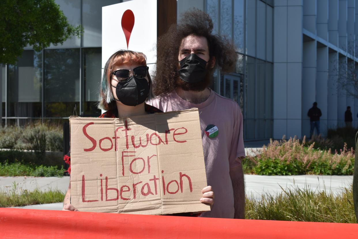 Two Google protesters, one of whom is holding a sign that says "software for liberation."