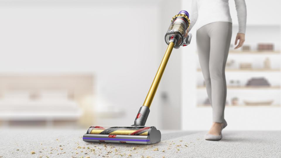 woman using the Dyson V11 Outsize Pro stick vacuum 