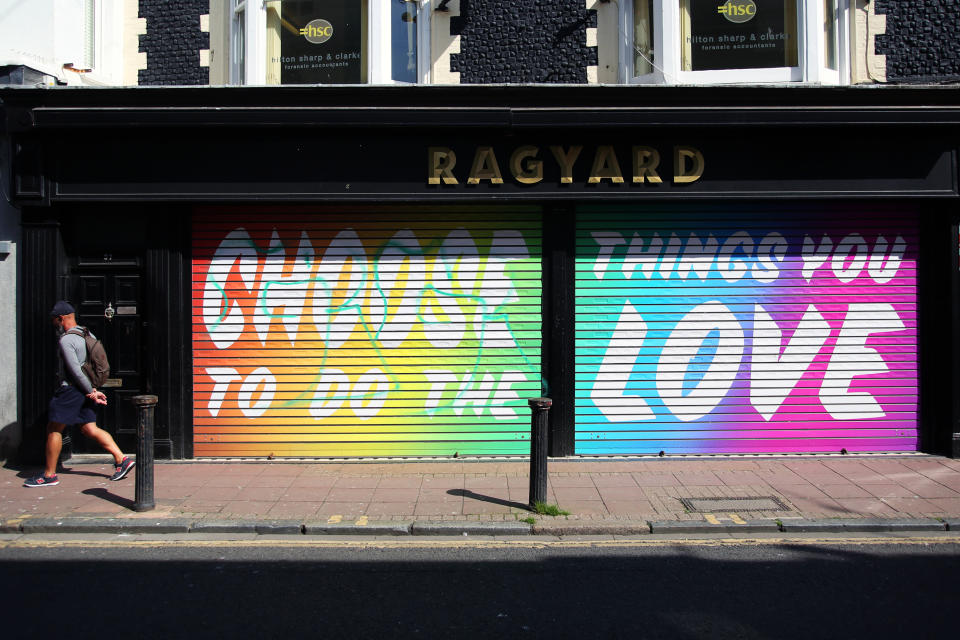 A man walks past a colourful message outside of a shop saying 'Choose to do the things you love' in Brighton as the UK continues in lockdown to help curb the spread of the coronavirus.