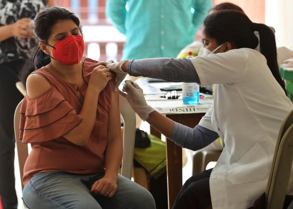 A woman receives the AstraZeneca COVID-19 vaccine at an apartment building in Bengaluru, India.